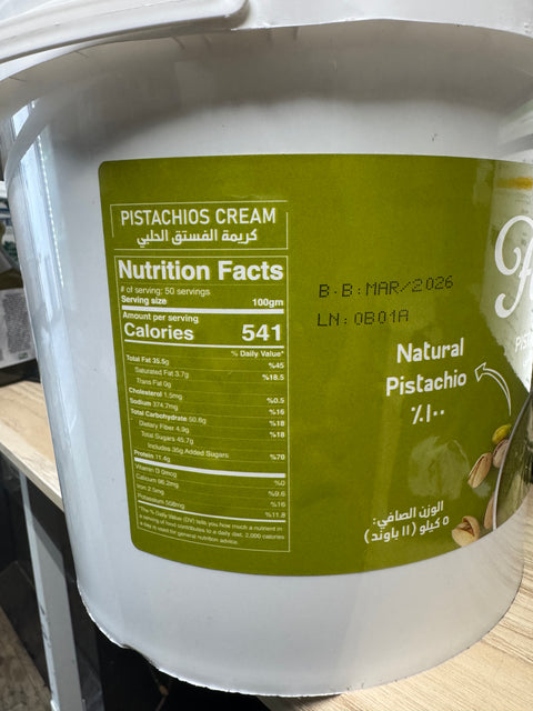Close-up of the nutritional facts label on the Fancy Pistachio Cream 5kg - 11lb Jar - Luxurious Spread from Finest Dubai Pistachios by ALBASHA Store, providing detailed serving information.