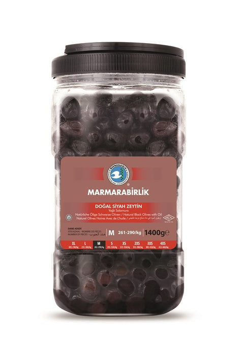 A jar of Marmarabirlik Natural Black Olives, displaying the label which includes product details such as 'Doğal Siyah Zeytin', weight (1400g), and size category ('M' for medium). The jar is transparent, showcasing the olives inside, with a dark lid at the top.