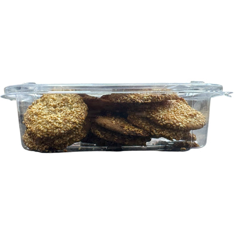 Side view of Albasha Barazek cookies in a transparent container, highlighting the texture and sesame coating.
