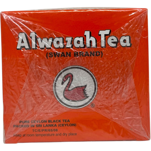 Alwazah black loose tea with cardamom tea package on a wooden surface.