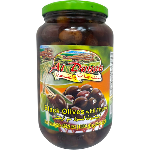 Al Dayaa black olives with thyme in a glass jar, showcasing their rich color and texture for culinary enthusiasts.