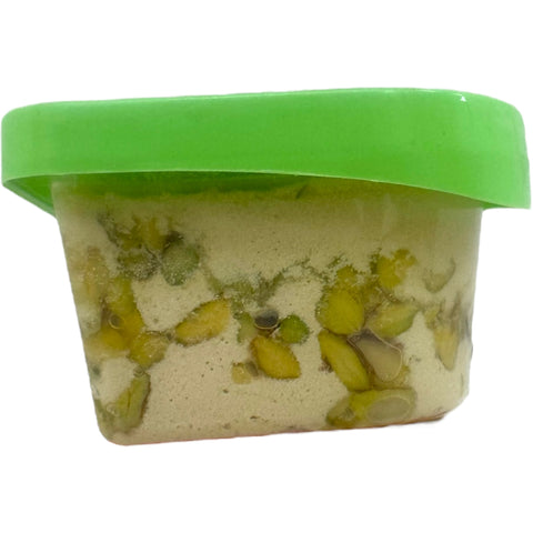 Yafa halva w pistachio 400g displayed on a wooden table, emphasizing the natural ingredients and authentic flavor of pistachio halva 400g.