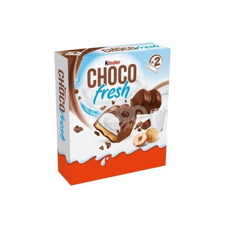 Close-up of Kinder Choco Fresh packaging showcasing rich chocolate-covered treats, highlighting milky cream filling and featuring additional hazelnuts and a glass of milk in the background.