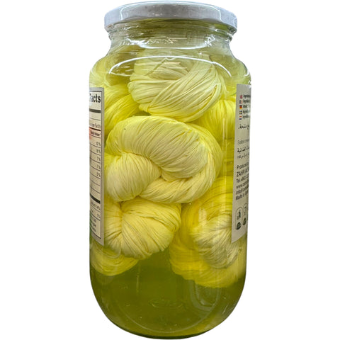 Close-up view of Alsham Syrian string cheese, emphasizing its stretchiness and traditional preparation.