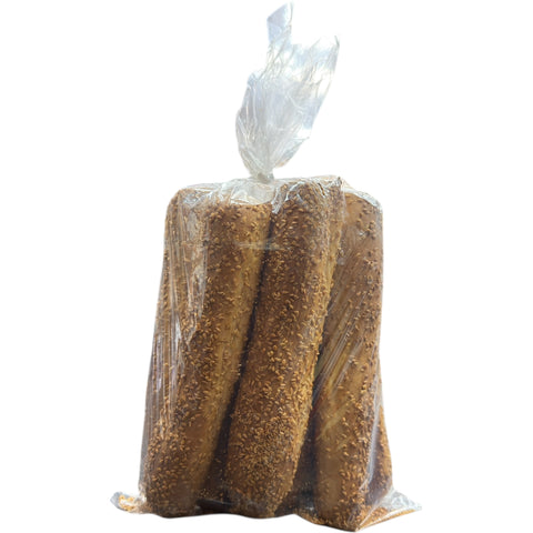 Sesame Breadsticks – Olive Mountain Bakery artisanal breadsticks displayed on a wooden platter, perfect for snacking.