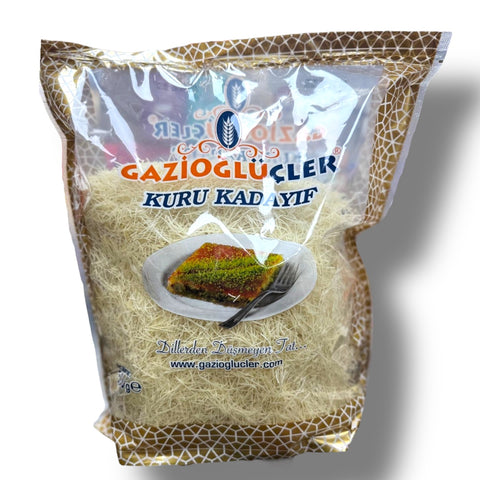 The Gazioglu Kuru Kadaif 500Gr - Premium Kunafe Dough for Authentic Dessert Creations by ALBASHA Store, displayed in its packaging featuring a slice of kunafe on a plate. Perfect for creating delicious desserts, including the highly sought-after dubai chocolate srtrawberry cup.