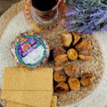 Sun dried figs pack with dried figs, crackers, tea, and lavender on a woven placemat