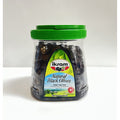 Ikram Natural Black Olives packaging featuring a transparent container with a green lid, showcasing the dark olives inside. The label includes the product name in English and additional translations, highlighting the net weight of 24.69 ounces (700g). The background is plain, emphasizing the product.