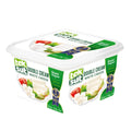 Teksüt Double Cream White Cheese packaging displayed in a white container, featuring fresh ingredients like tomato and herbs, and labels indicating 'White Cheese' and 'Double Cream' along with the awards for taste.